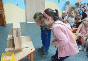 dwoje dzieci patrzące na sztuczna strukturę ula