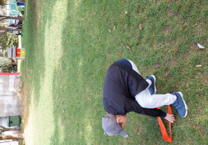 chłopiec z szarfą na trawie