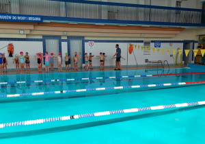 grupa dzieci ustawiona przed pływalnią