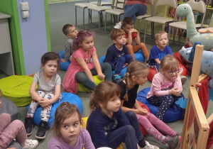 dzieci oglądają teatrzyk o dinozaurach