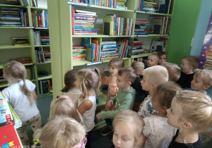 grupa dzieci przed półkami z książkami