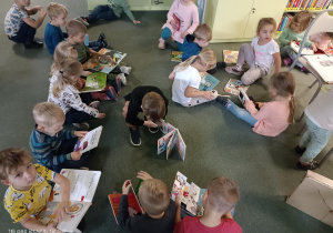 grupa dzieci ogląda ksiązki