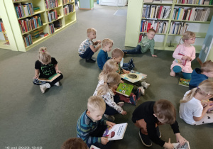 grupa dzieci ogląda różne książki