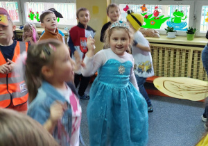 dziewczynka w niebieskiej sukience tańczy wraz z innymi dziećmi