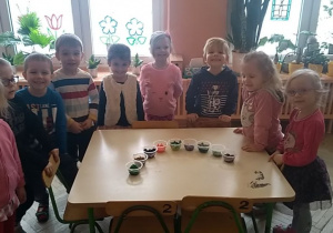 dzieci wokół stołu z kubeczkami śniegu