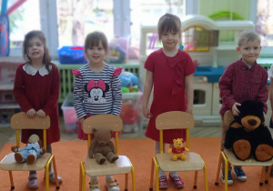 dzieci stoją za krzesłami a misie na krzesłach