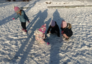 dzieci biorą śnieg do rąk
