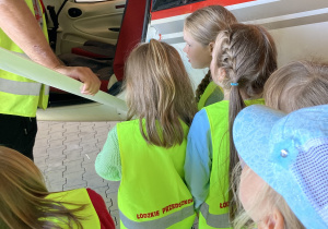 Dzieci stoją przy małym samolocie szkoleniowym