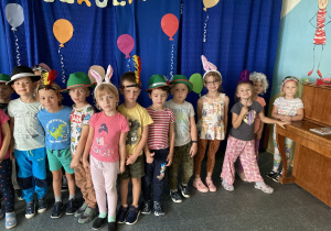 Dzieci stoją w zabawnych kapeluszach