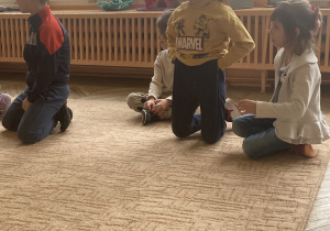 dzieci siedzą na dywanie
