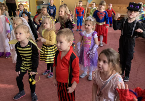 dzieci tańczą w przebraniach karnawałowych