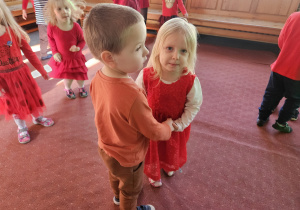 dziewczynka z chłopcem tańczą w kółeczko