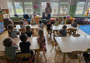 pani pokazuje grupie dzieci dwa zabawkowe koty