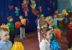 dzieci trzymają kolorowe pompony