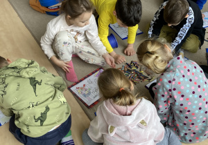 grupa dzieci koloruje ilustracje
