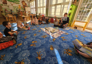 Dzieci na dywanie z ilustracjami w środku koła