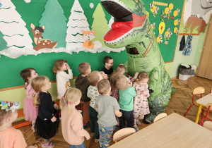 dzieci witają się z wielkim dinozaurem