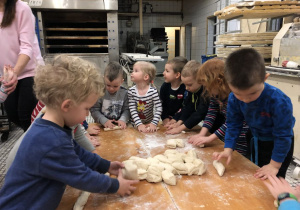 dzieci ugniatają ciasto chlebowe