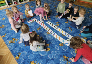 dzieci siedzą wokół gry domino