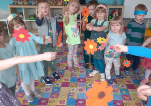grupa dzieci z papierowymi kwiatami