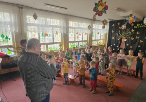Dzieci pokazują jak grają na puzonie