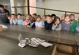 grupa dzieci stoi za stołem