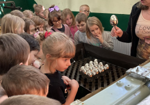 dzieci patrzą na srebrne bombki w kształcie jajeczka