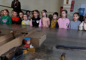 grupa dzieci stoi za stołem w fabryce bombek