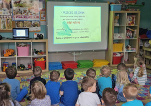 Dzieci oglądają film na tablicy multimedialnej