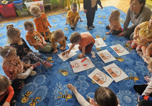 Dzieci układają sylwety marchewek do koszyków