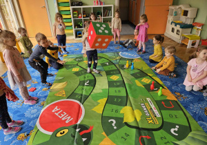 Dzieci grają w węża na ogromnej planszy
