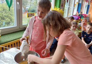 Dwie dziewczynki miksują jajka z cukrem