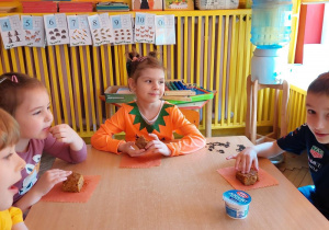 Czworo dzieci przy stole je ciasto