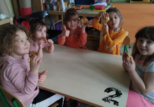 Dziewczynki przy stole jedzą ciasto marchewkowe