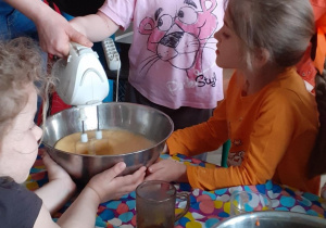 Dziewczynka miksuje mikserem jajka z cukrem