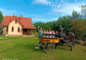 Dzieci na bryczce z panią machają