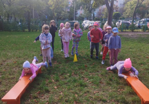 dzieci podciągają się na ławce