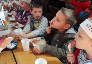 dzieci jedzą kiełbaski