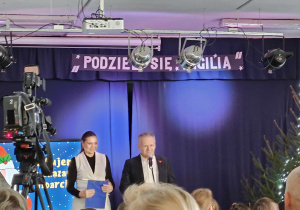 mężczyzna i kobieta na scenie przed mikrofonem