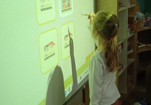 dziewczynka przed tablicą interaktywną z długopisem